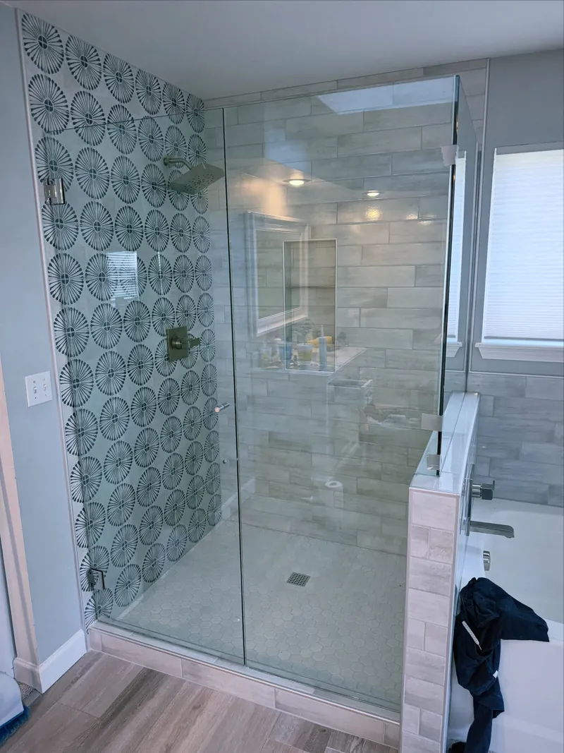 Frameless walk-in shower with patterned tile wall